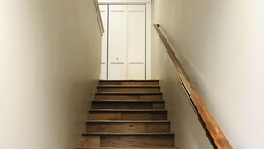 A wooden staircase with a handrail leading to a white door at the top. - New Luxury Condo in Downtown Salida #0677 (Salida)