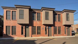 A row of three-story brick townhouses with large windows and a flat roof. - New Luxury Condo in Downtown Salida #0677 (Salida)