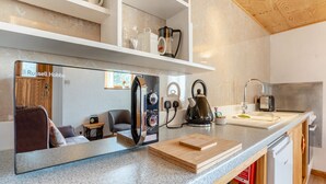 Una cocina moderna con horno empotrado, hervidor y cafetera.