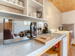 A modern kitchen with a built-in stove, kettle, and coffee maker.