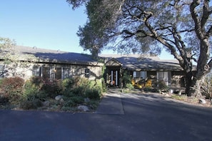 A two-story house with a covered porch and a driveway leading to the front door.