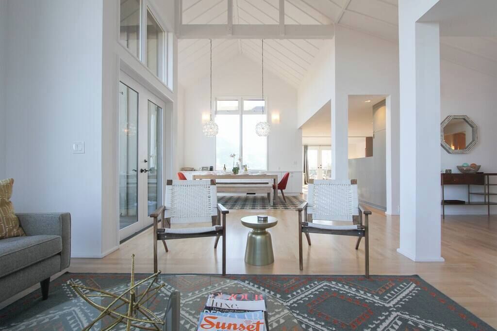 A spacious living area with a sofa, chairs, a coffee table, and a rug.