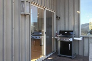 An outdoor grill area with a sliding glass door leading to a patio. - Modern Panoramic Hillside Escape (Santa Rosa)
