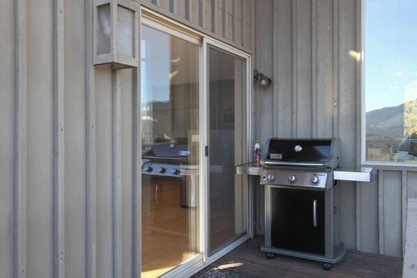 An outdoor grill area with a sliding glass door leading to a patio.