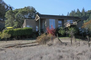 A two-story wooden house with a covered porch and a small deck. - Modern Panoramic Hillside Escape (Santa Rosa)