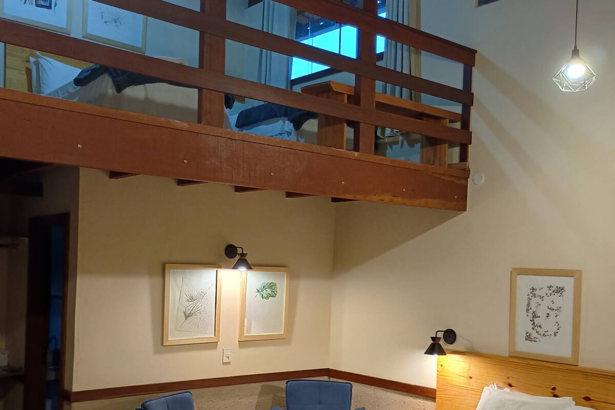 Ein Zimmer mit einem Etagenbett, zwei Stühlen, einem Nachttisch und Bildern an den Wänden.
