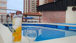 A poolside view with a glass of iced drink and a clear glass. - Hotel Gran International (Villa Gesell)