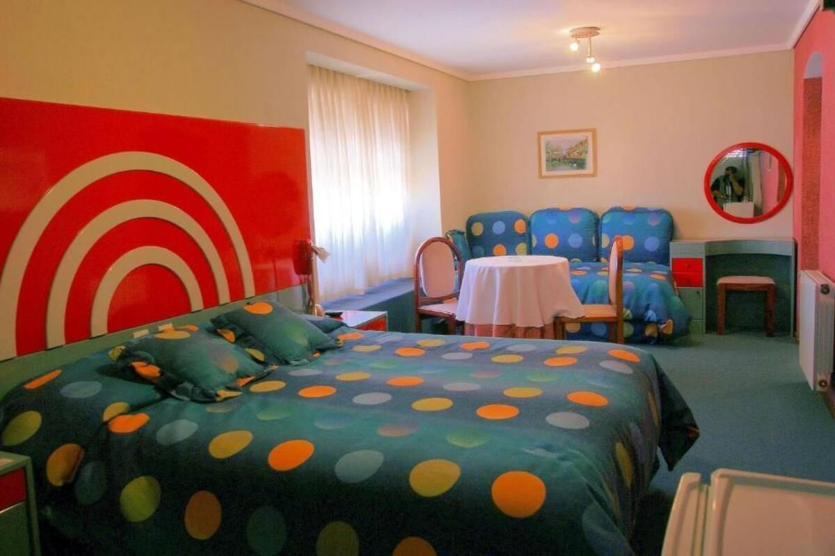 Une pièce comprenant un lit, une petite table, une chaise et un canapé.