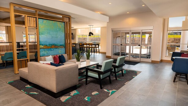 A modern living room with a sofa, chairs, a coffee table, and a large painting. - Hyatt House Nashville/Franklin/Cool Springs (Franklin)