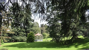 Un kiosque dans un parc, avec un banc à proximité.