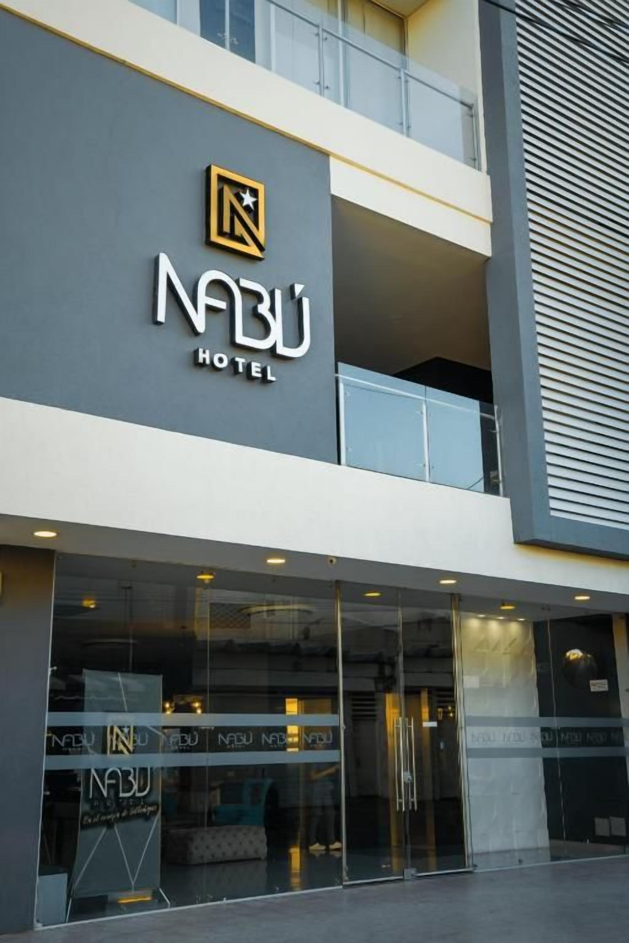 A hotel entrance with a glass facade, a logo with a star, and the name 'NABU HOTEL' prominently displayed.