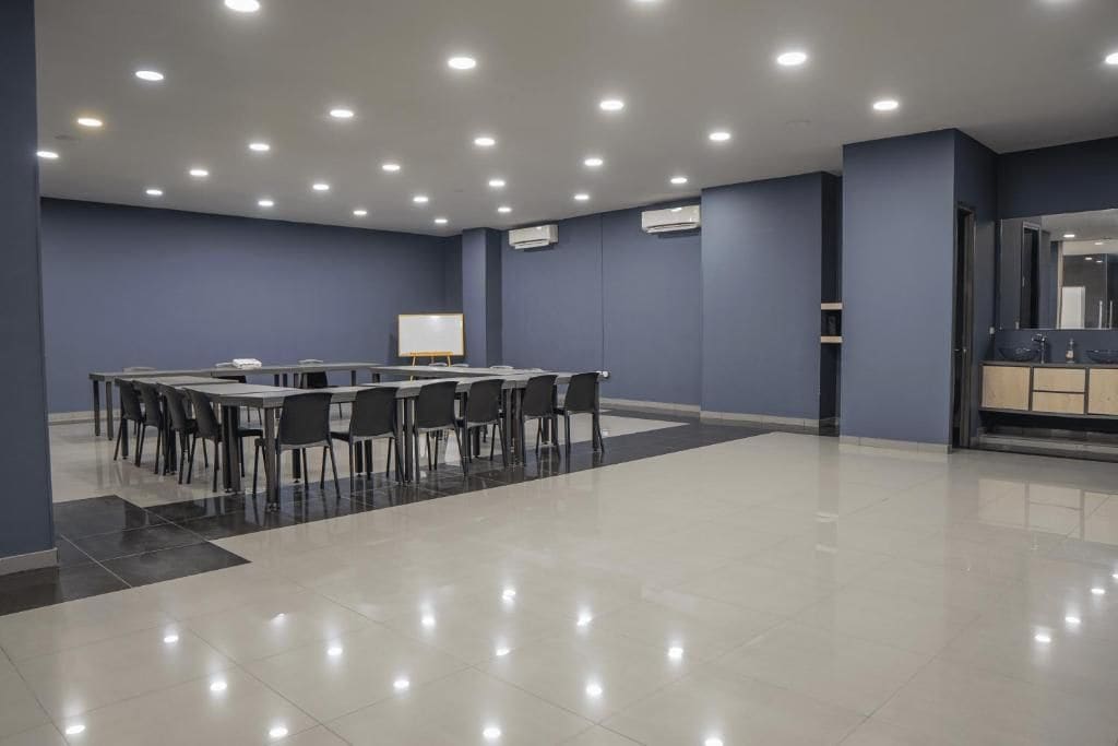 A conference room with a long table, chairs, and a whiteboard.