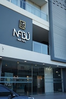 Un hotel con fachada moderna, un logotipo destacado y entrada de cristal.