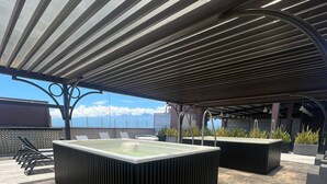 Modernilla designilla toteutettu ulkouima-allasalue, johon kuuluu suuri suorakaiteen muotoinen allas ja useita oleskelualueita.
