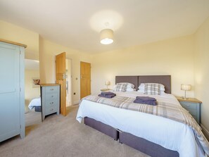 A bedroom with a bed, bedside tables, a wardrobe, and a ceiling light.