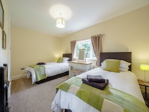 A hotel room with two beds, a window with curtains, a bedside table, and a lamp. - 5 bedroom accommodation in Crossway Green, near Stourport-on-Severn (Crossway Green, near Stourport-on-Severn)