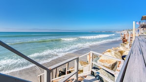 A wooden boardwalk leading to a beach with waves, a rocky shoreline, and a clear blue sky. - 35679 Beach Rd ocean front newly remodeled 2025
 Dana Point Permit STR14-0101 (Dana Point)