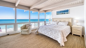 A bedroom with a large window overlooking the ocean, a bed, a chair, and a nightstand with a lamp. - 35679 Beach Rd ocean front newly remodeled 2025
 Dana Point Permit STR14-0101 (Dana Point)
