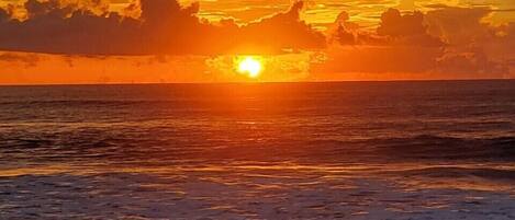A sunset over the ocean with waves.