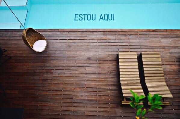 A wooden floor with a hanging chair and a bench.