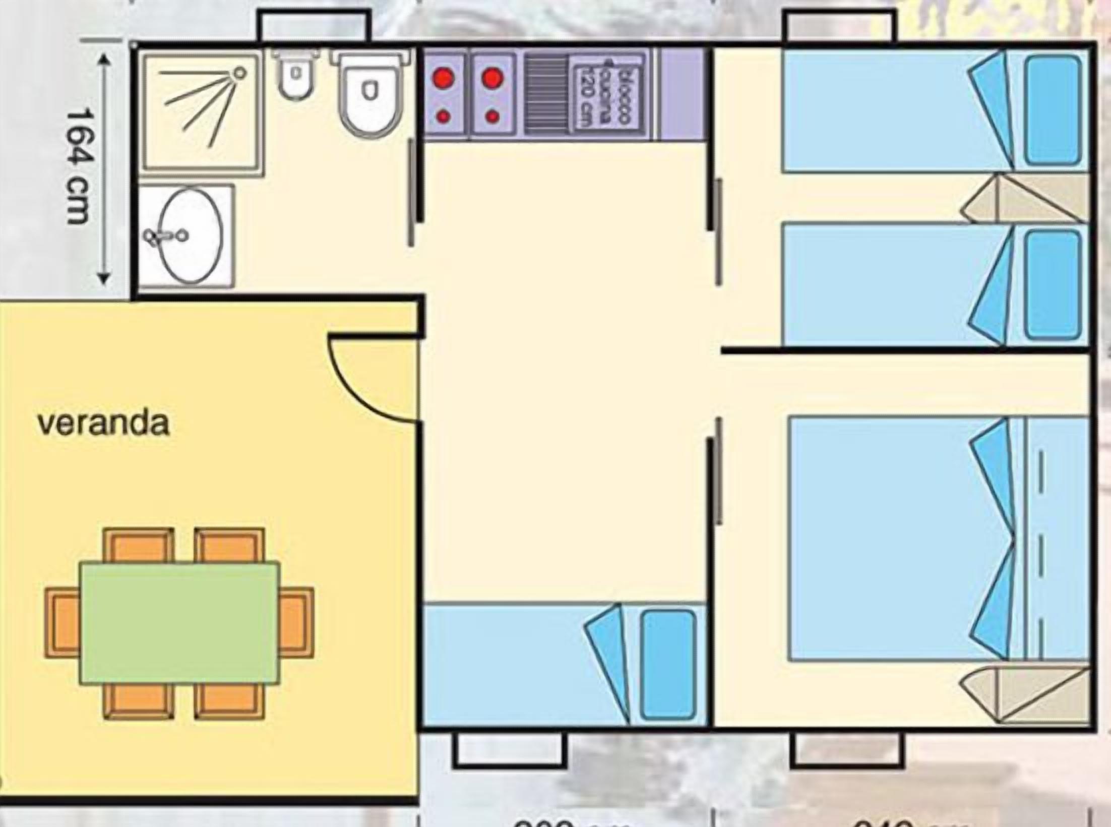Un plan d’aménagement de chambre d’hôtel comprenant un lit, une petite salle de bain, un coin cuisine et un espace repas.