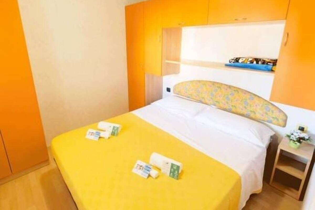 Ein Hotelzimmer mit Bett, Nachttisch und einem kleinen Tisch mit Blumen.