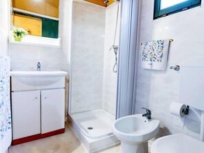A modern bathroom with a shower, sink, and bidet. - Villaggio Camping Duca Amedeo (Martinsicuro)