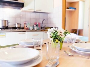 Full-sized fridge, stovetop, high chair, cookware/dishes/utensils