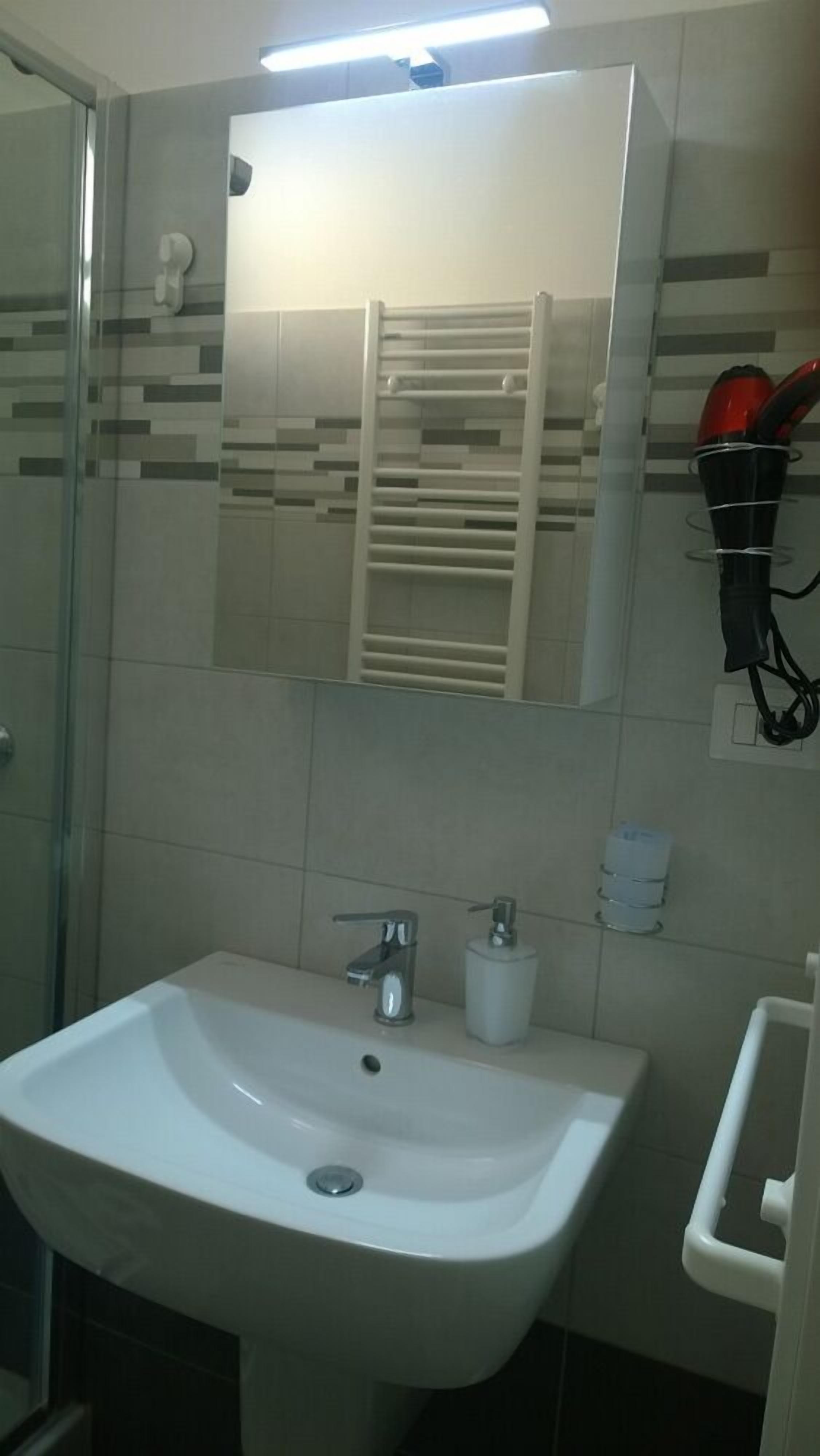 A bathroom with a white sink, a mirror, and a towel rack.