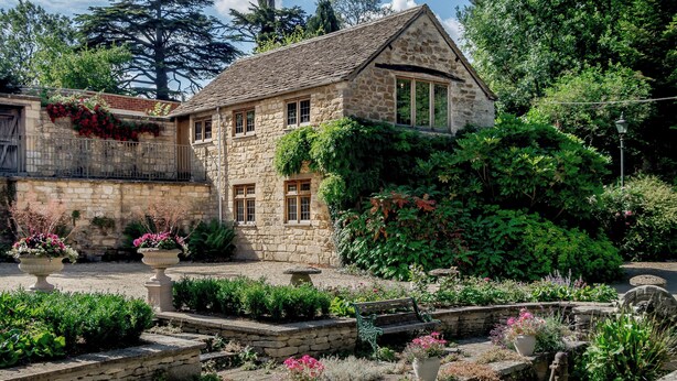 A stone house with a garden, a stone bench, and a small stream. - 2 bedroom accommodation in Uley, near Dursley (Uley, near Dursley)