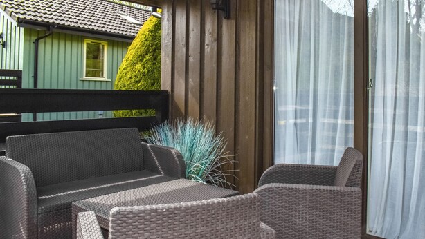 A patio with wicker furniture, a wooden bench, and a potted plant. - 2 bedroom accommodation in Yanwath, near Penrith (Yanwath, near Penrith)