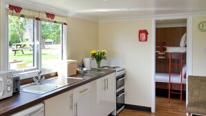 Une cuisine moderne équipée d’un évier, d’une cuisinière et d’un coin repas avec une table et des chaises.