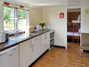 Une cuisine moderne équipée d’un évier, d’une cuisinière et d’un coin repas avec une table et des chaises.