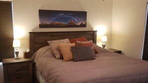 A neatly made bed with a headboard, two bedside lamps, and a nightstand with a lamp and a tissue box. - Slickrock Sands - Sleeps 8! Pet/bike friendly. (Moab)
