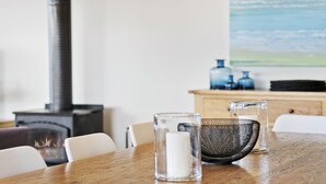 Une table à manger avec des chaises, une bougie et de la verrerie.