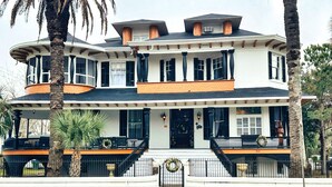 A two-story house with a wrap-around porch, a front entrance with a door, and a number '511' on the front.
