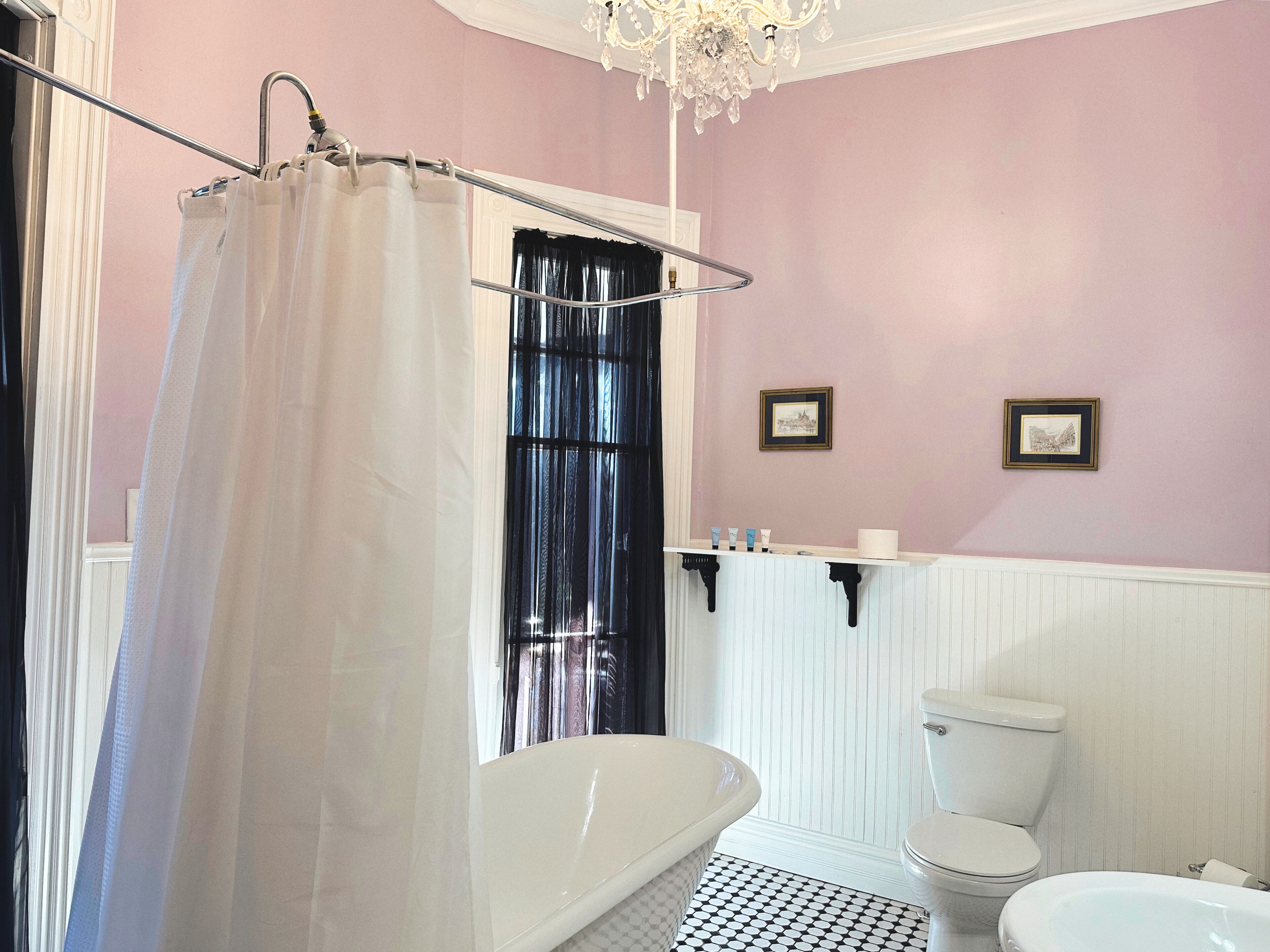 A bathroom with a bathtub, toilet, and shower curtain.