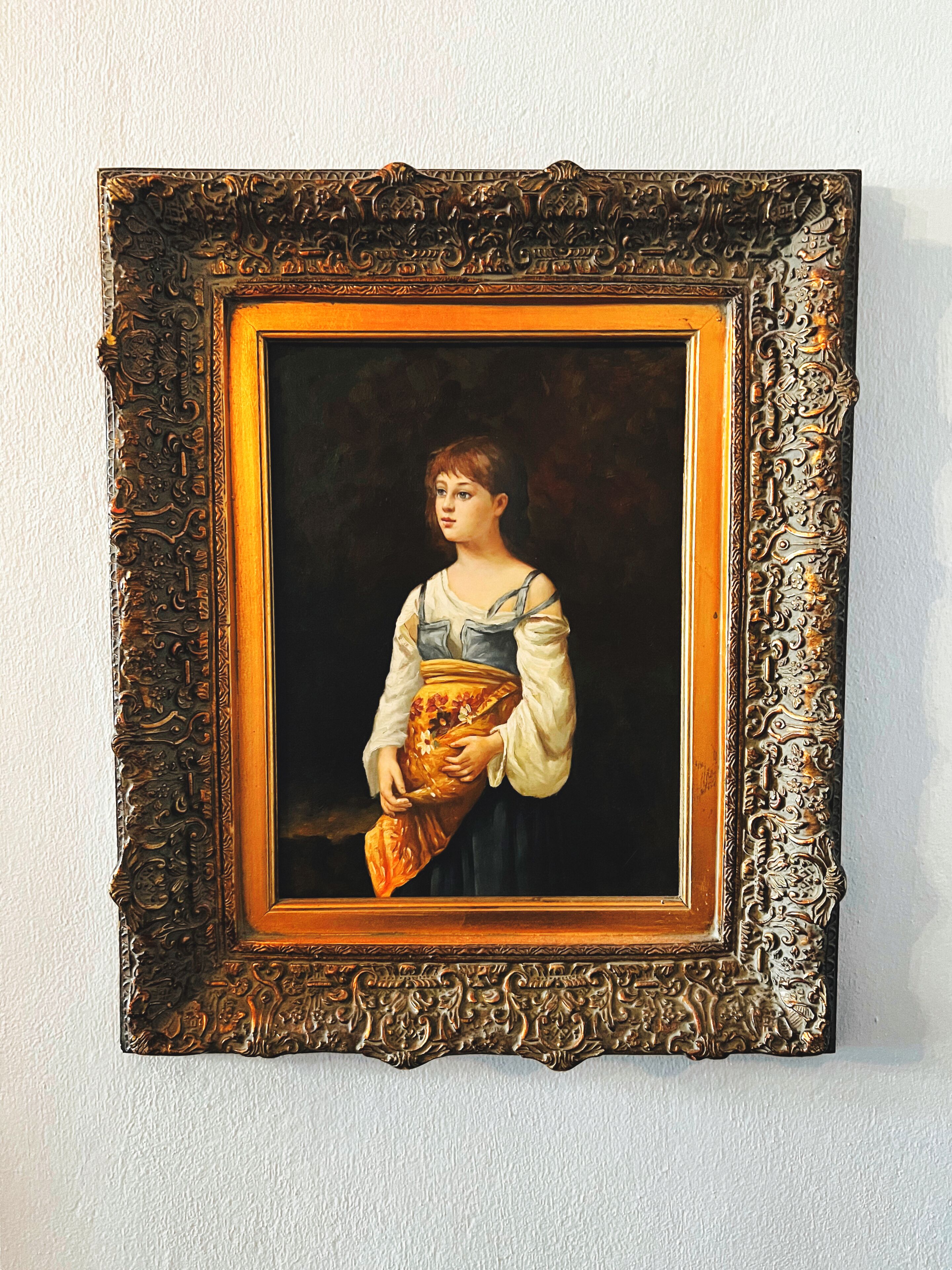 A framed portrait with an ornate, dark frame.