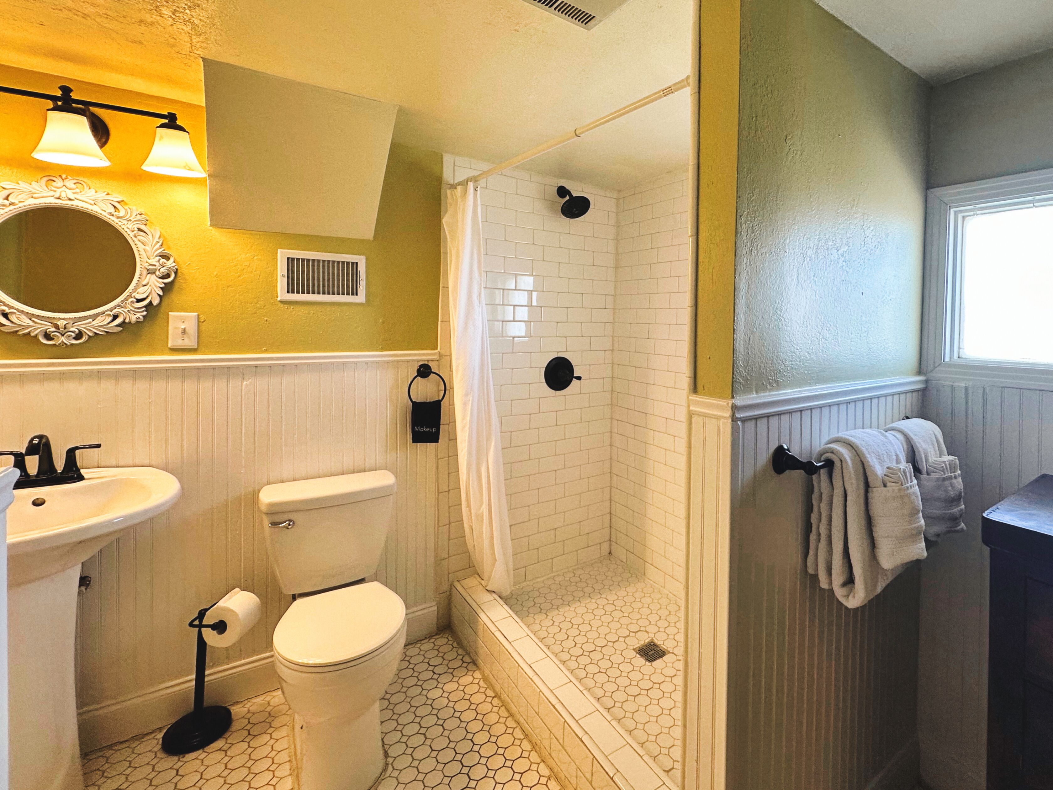 A bathroom with a toilet, sink, and shower.