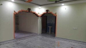 Een kamer met een marmeren vloer, een plafondventilator en een deur die leidt naar een andere kamer.