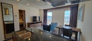 Suite Deluxe, 2 camas matrimoniales, para no fumadores | Área de sala de estar | Televisión de 49 pulgadas con canales por cable