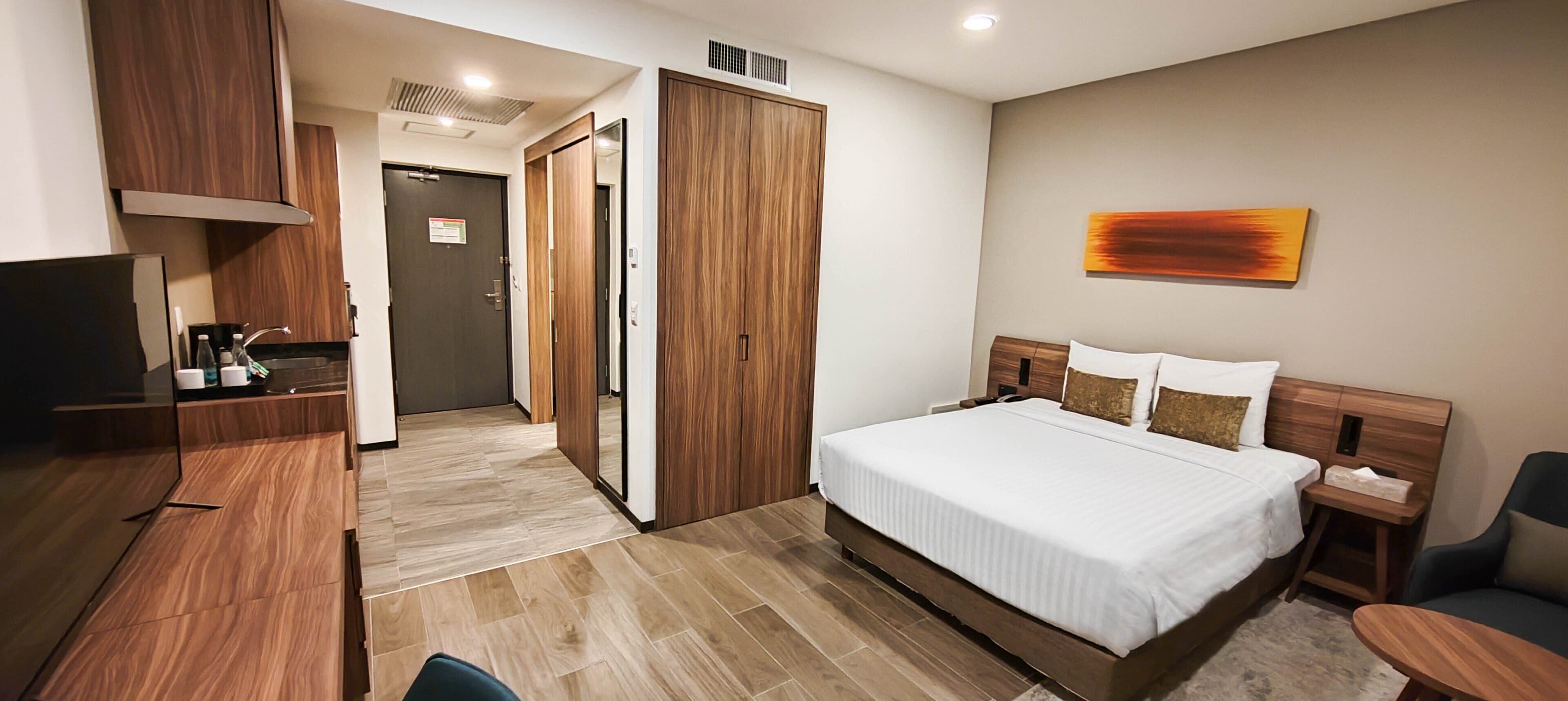 Een hotelkamer met een bed, nachtkastje, stoel en bureau met een stoel.