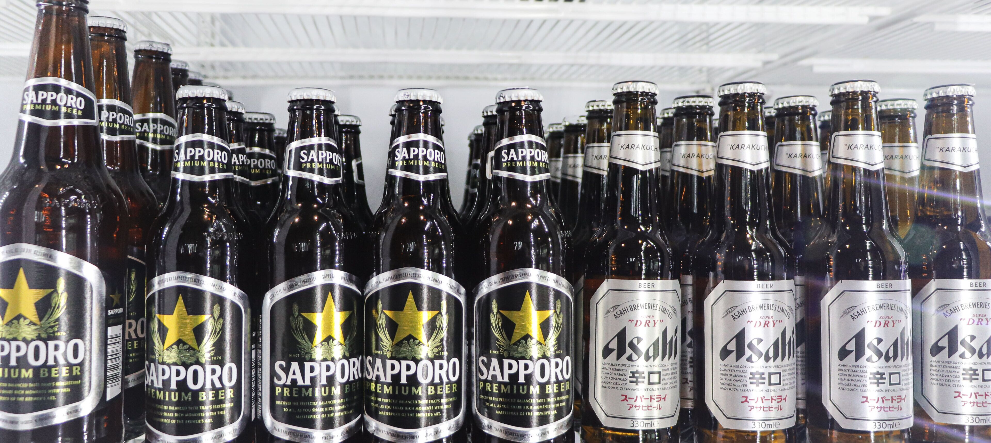 A refrigerated display of Sapporo Premium Beer bottles.