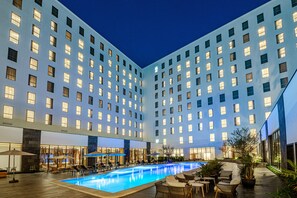 Un hôtel doté d’une piscine, de plusieurs étages et d’une architecture moderne.