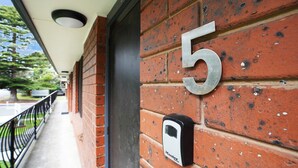 A brick wall with the number 5, a door, and a security device labeled "Master Tech." - Perfect for your beach holiday, you are only a stone's throw to the Port Fairy East Beach (Port Fairy)
