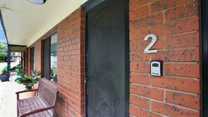 A brick building with a number '2' sign, a door, and a bench outside. - Perfect for your beach holiday, you are only a stone's throw to the Port Fairy East Beach (Port Fairy)