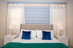 A neatly made bed with a tufted headboard, two bedside tables with lamps, and sheer curtains. - Amazing 6bds Single Home With Private Pool St7040 (Davenport)