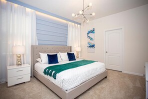 A bedroom with a bed, nightstands, a chandelier, and a door. - Amazing 6bds Single Home With Private Pool St7040 (Davenport)