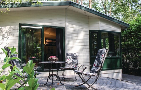 Una casa moderna con un patio que incluye una mesa y dos sillas.