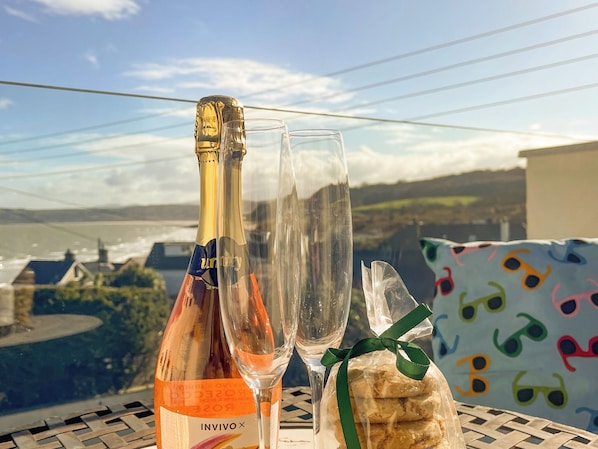 Una botella de vino Invivo, dos copas y un alimento envuelto sobre una mesa con vistas panorámicas.